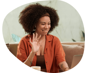 a woman smiling and waving at a screen